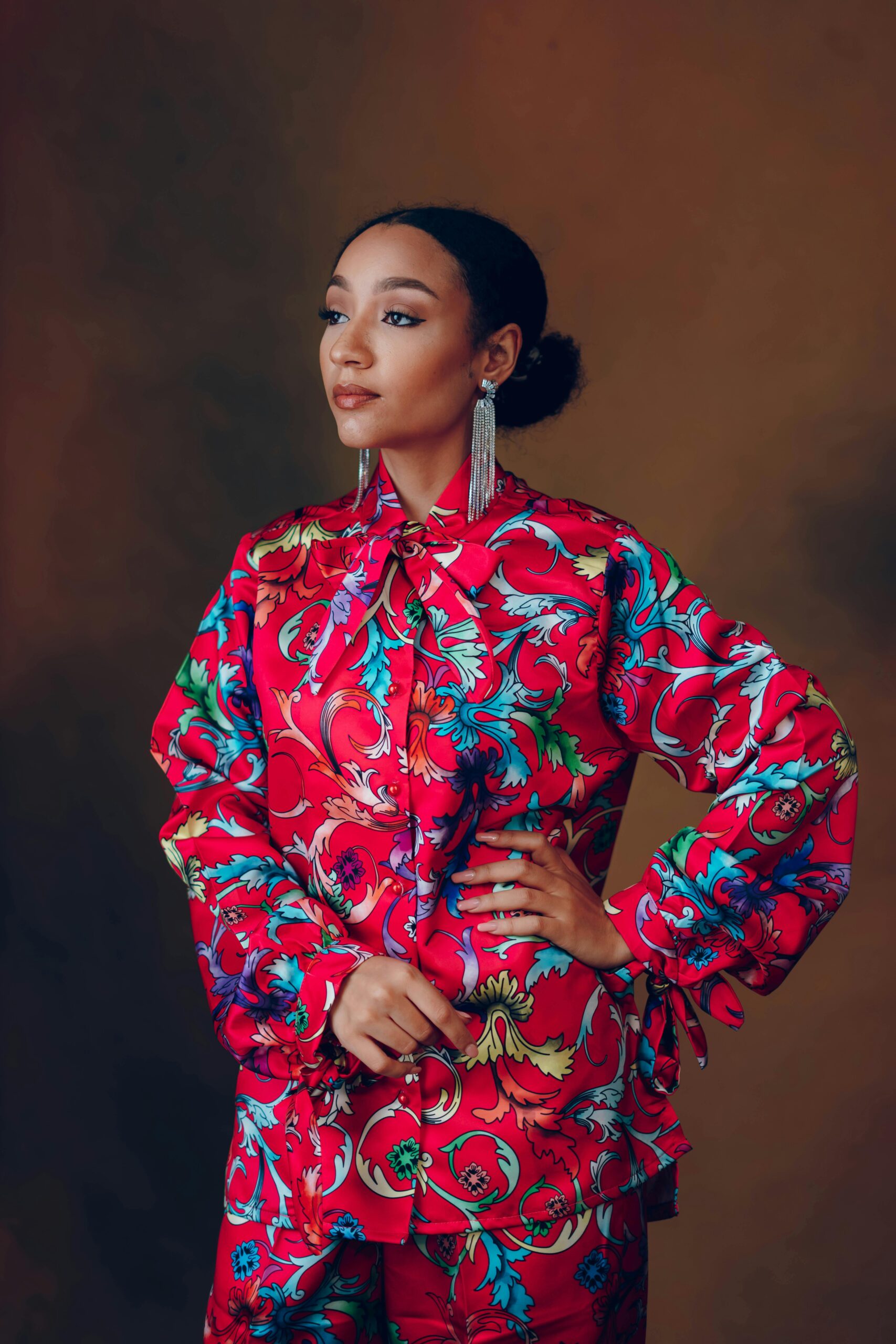 Elegant portrait of a woman in a vibrant floral dress exuding confidence and style.